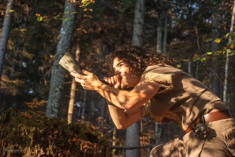 A band member in costume in the forest